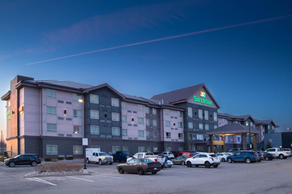 a hotel with cars parked in a parking lot at Sandman Hotel Oakville in Oakville