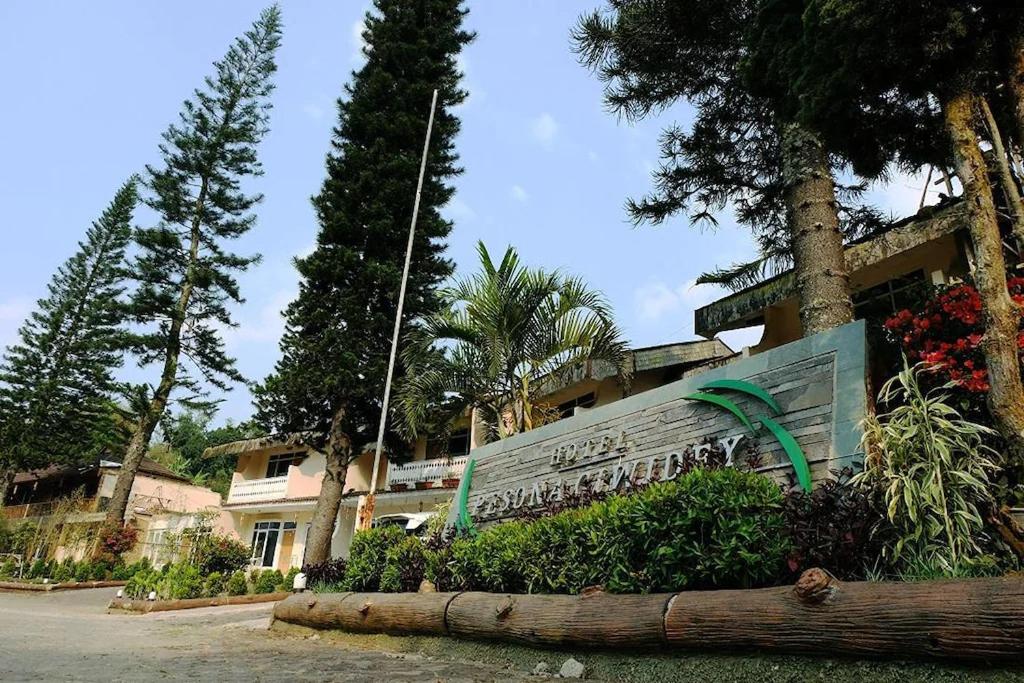 a sign in front of a building with trees at Hotel Pesona Ciwidey in Ciwidey