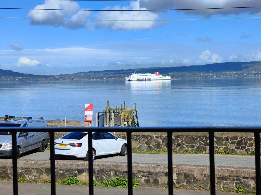 a white car and a cruise ship in the water at Holywood Sea Renity in Holywood