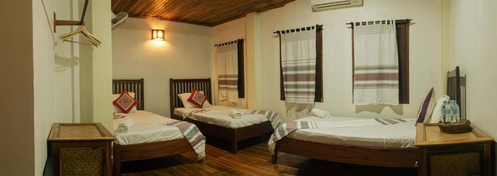 a room with two beds and two windows at laolulodge in Luang Prabang