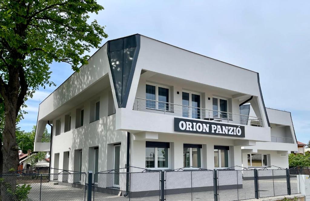 un edificio con un cartel que lee "Cebolla paza" en Orion Panzió, en Hajdúszoboszló