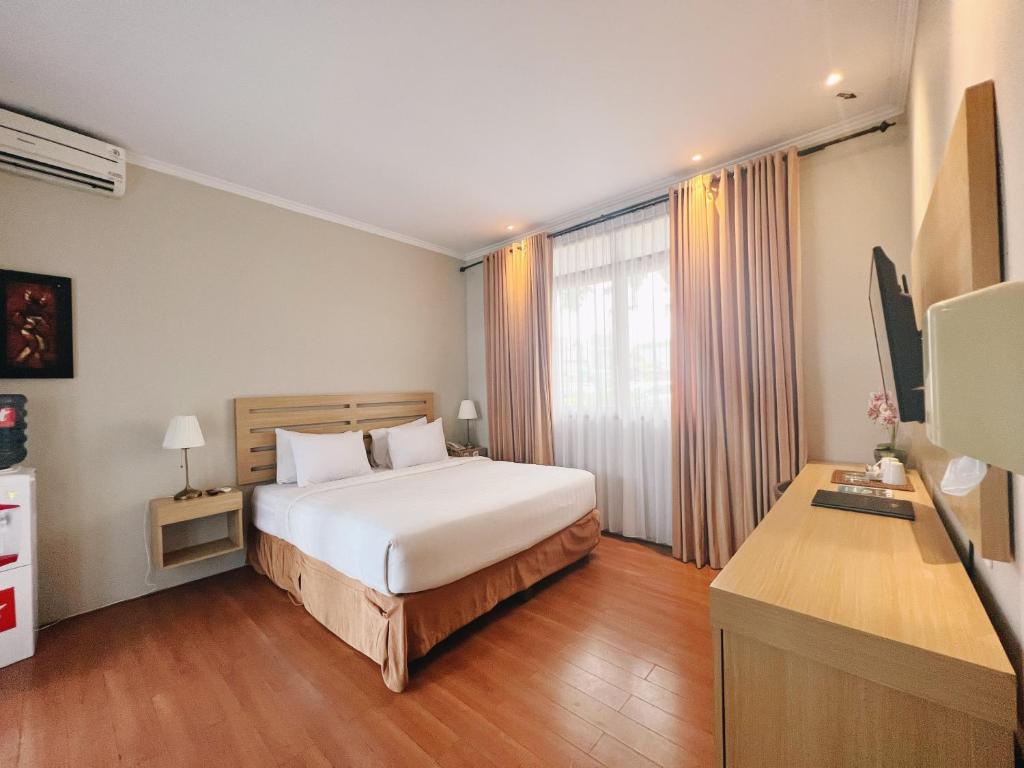 um quarto de hotel com uma cama e uma secretária em Sabda Alam Hotel & Resort em Garut