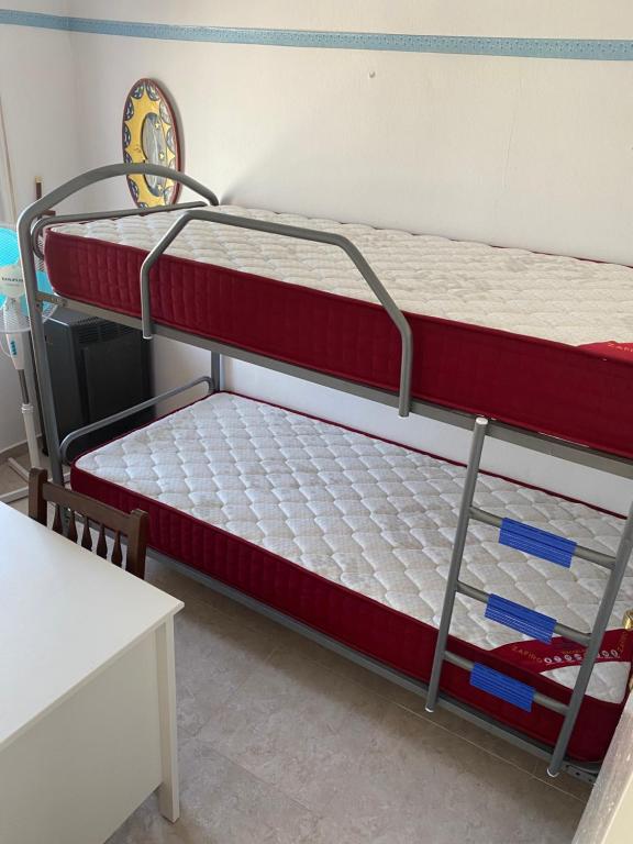 two bunk beds in a room with a table at 3 BDRM APART NEAR THE SEA! GREAT FOR KIDS! in Arenys de Mar