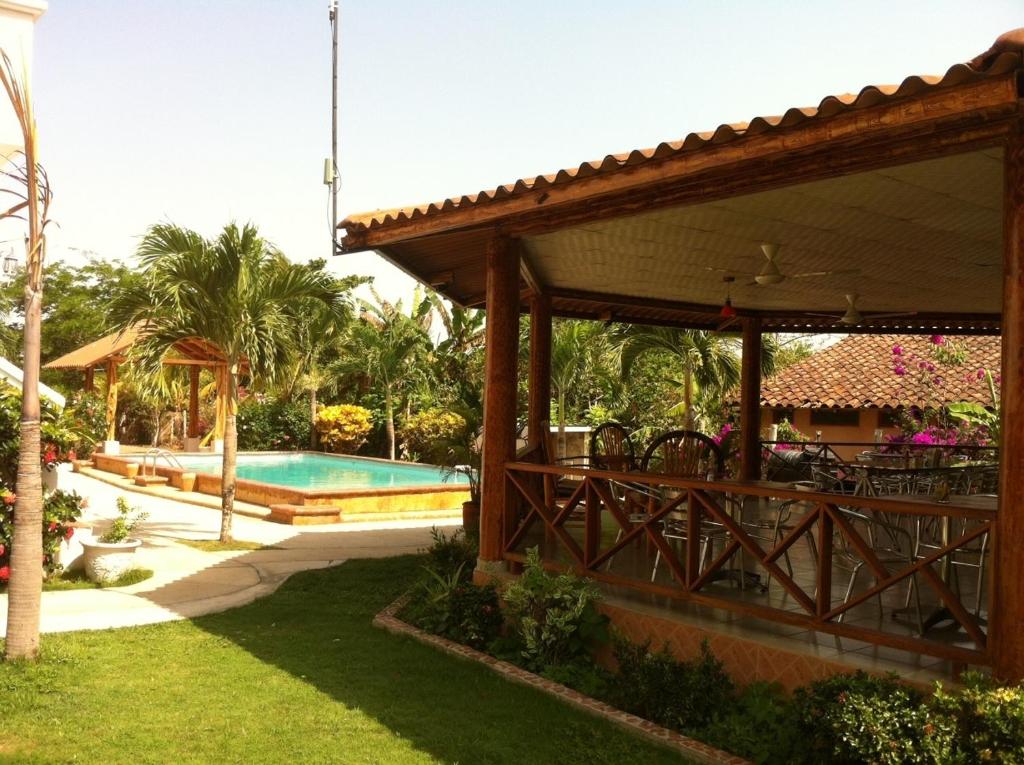 a pavilion with a table and chairs next to a pool at Casa Loma in Pedasí Town