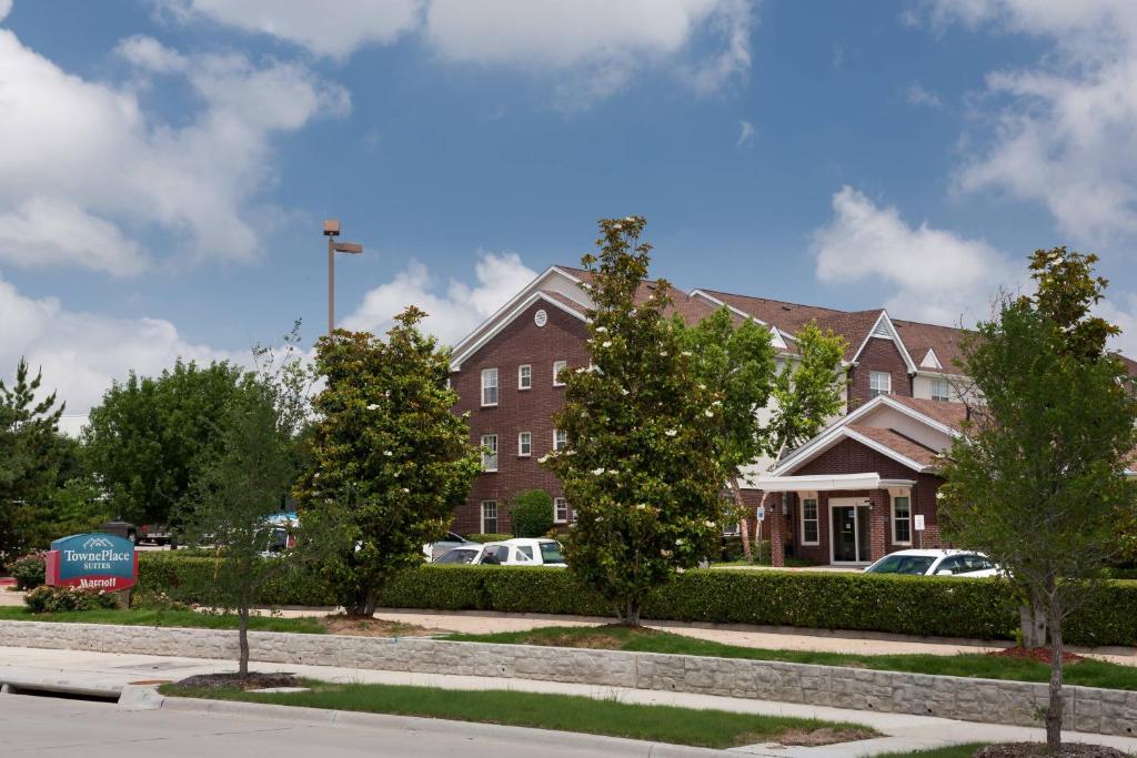un edificio de ladrillo con árboles delante de él en TownePlace Suites Dallas Arlington North, en Arlington