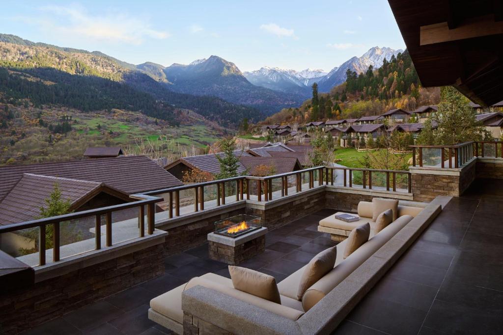 a patio with couches and a view of mountains at Rissai Valley, a Ritz-Carlton Reserve in Jiuzhaigou