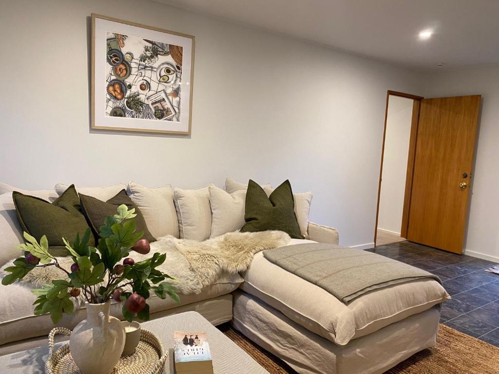 瓦納卡的住宿－Wanaka Deluxe Studio，带沙发和搁脚凳的客厅