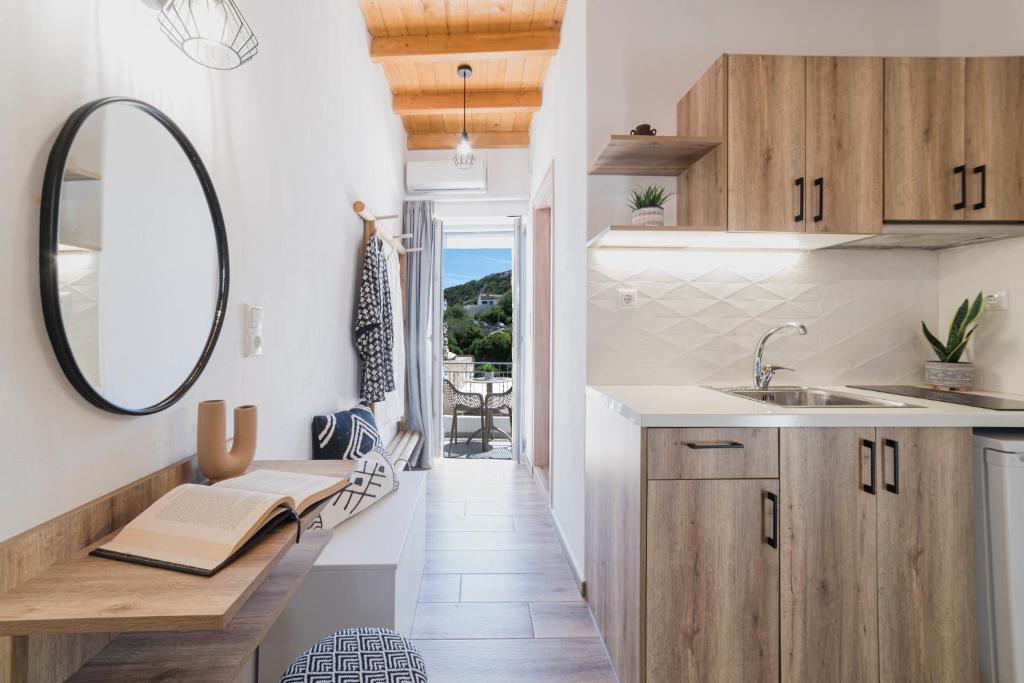 eine Küche mit einem Waschbecken und einem Spiegel in der Unterkunft VOLTO Suite in Kóronos