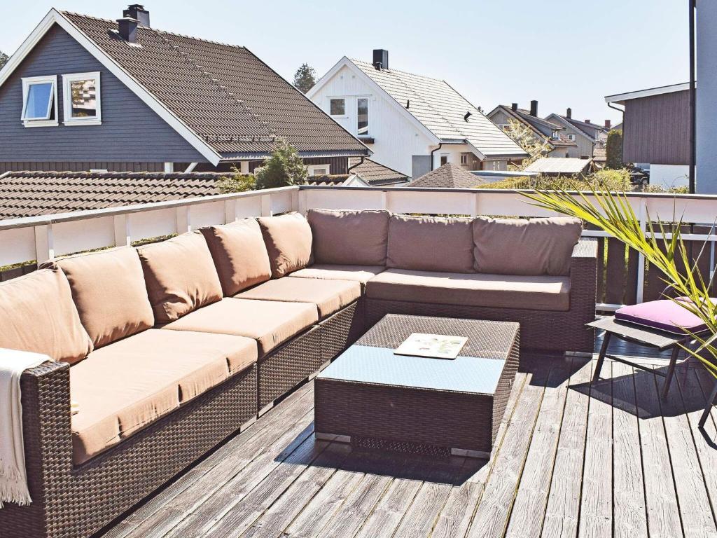 a brown couch on a deck with a table at Apartment Frederikstad II in Fredrikstad