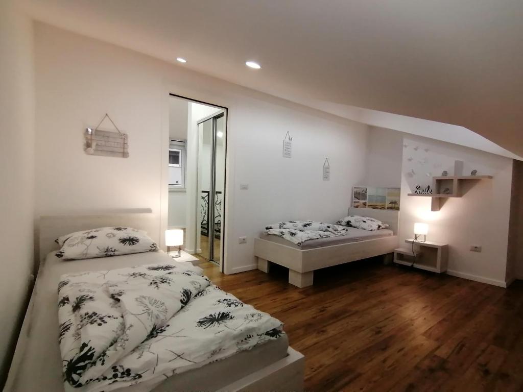 sypialnia z dwoma łóżkami i lustrem w obiekcie Apartmani Kiko w Poreču