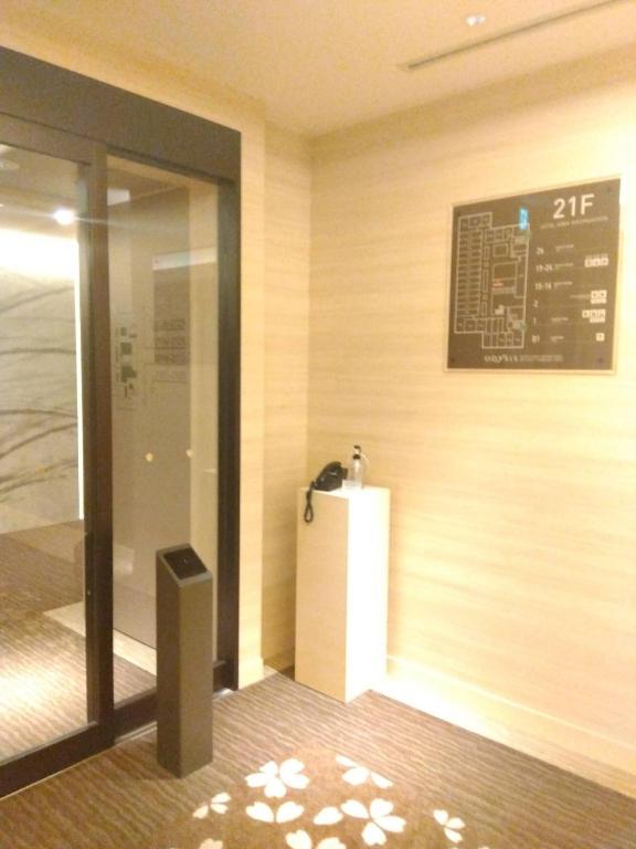 an entrance to a building with a sign on the wall at Odysis Suites Osaka Airport Hotel in Izumi-Sano