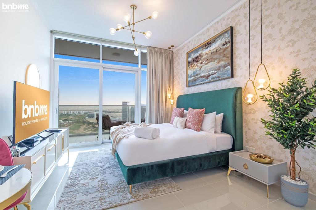 a bedroom with a large bed and a large window at bnbmehomes - Damac Hills Studio w City View - 2504 in Dubai