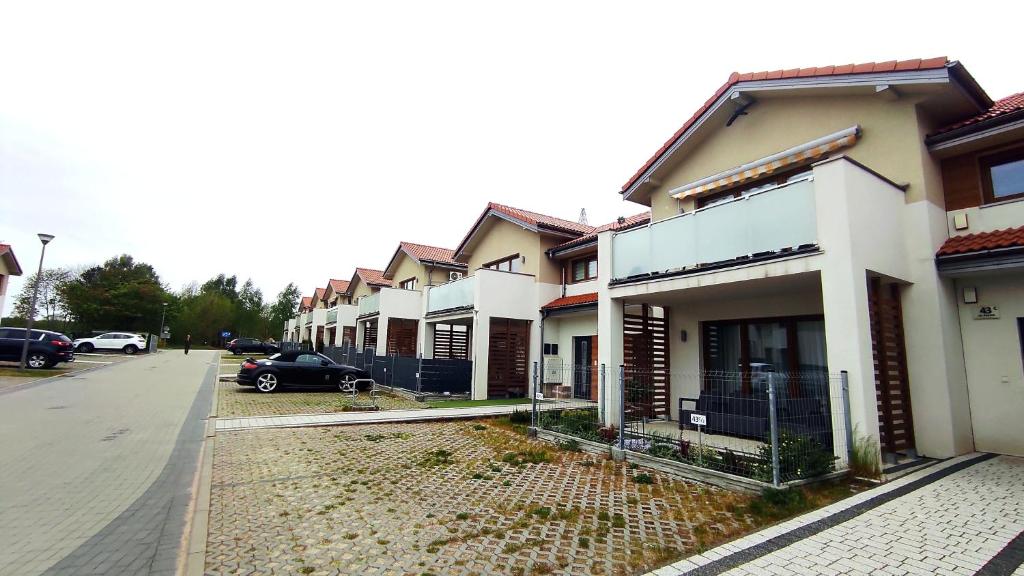 a row of houses on a street with parked cars at Dom z ogrodem Bursztynowa Polana in Ustka