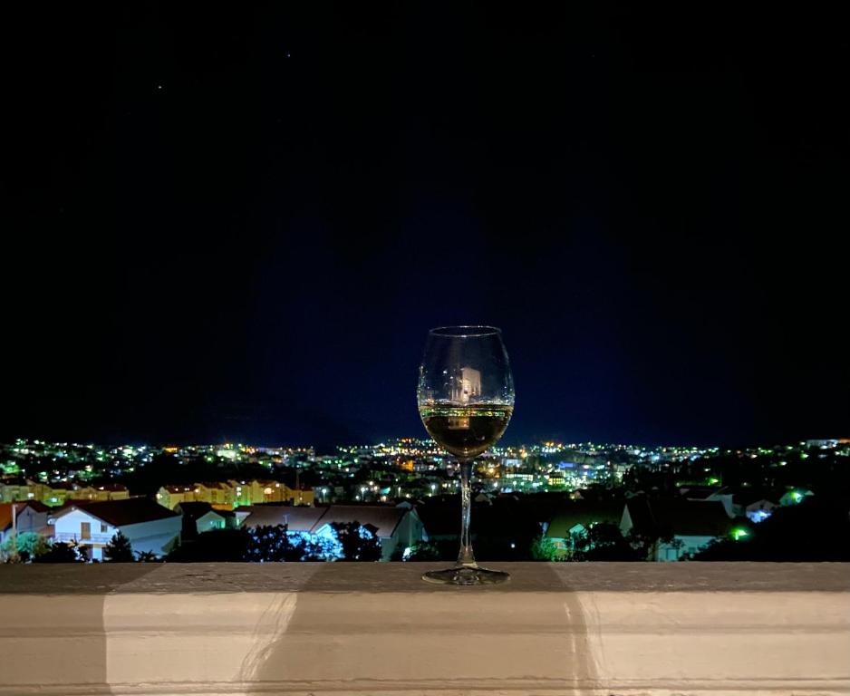 a glass of wine sitting on a ledge at night at Vizura in Trebinje