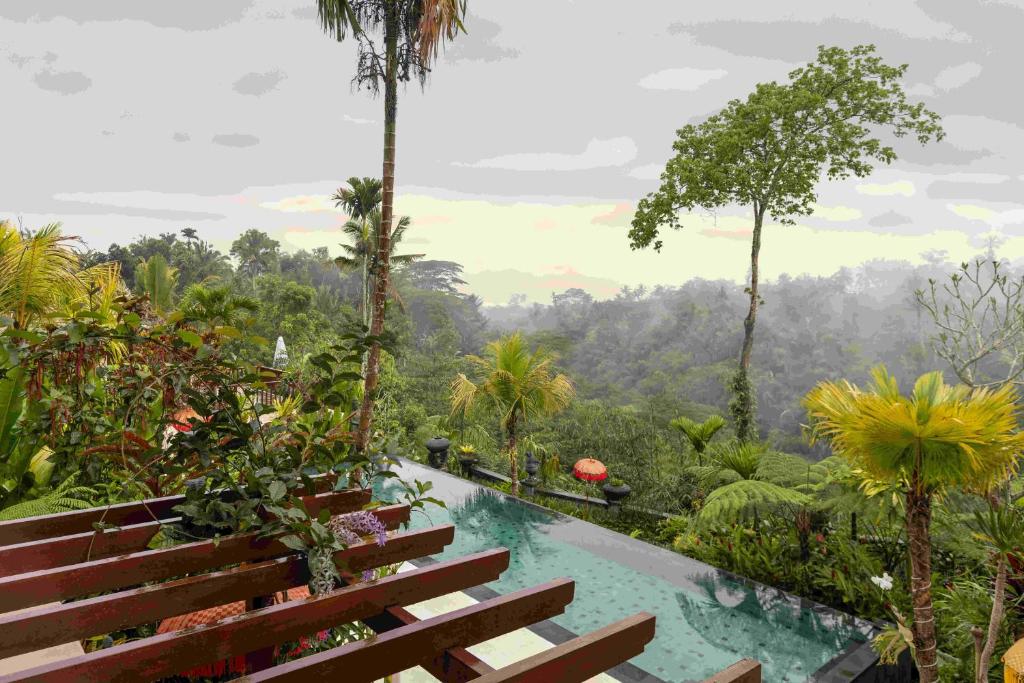 a swimming pool in the middle of a forest with trees at Villa Lembah Damai by Pramana Villas in Gianyar
