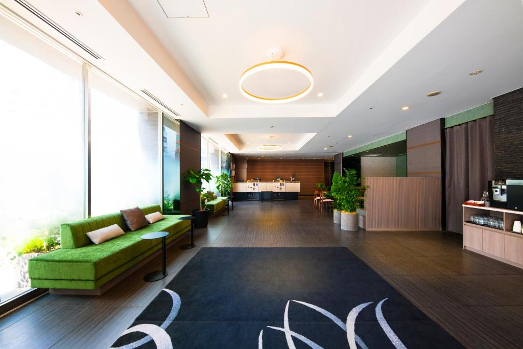 東京にあるヴィラフォンテーヌ東京九段下の緑のソファと敷物が備わるオフィスロビー