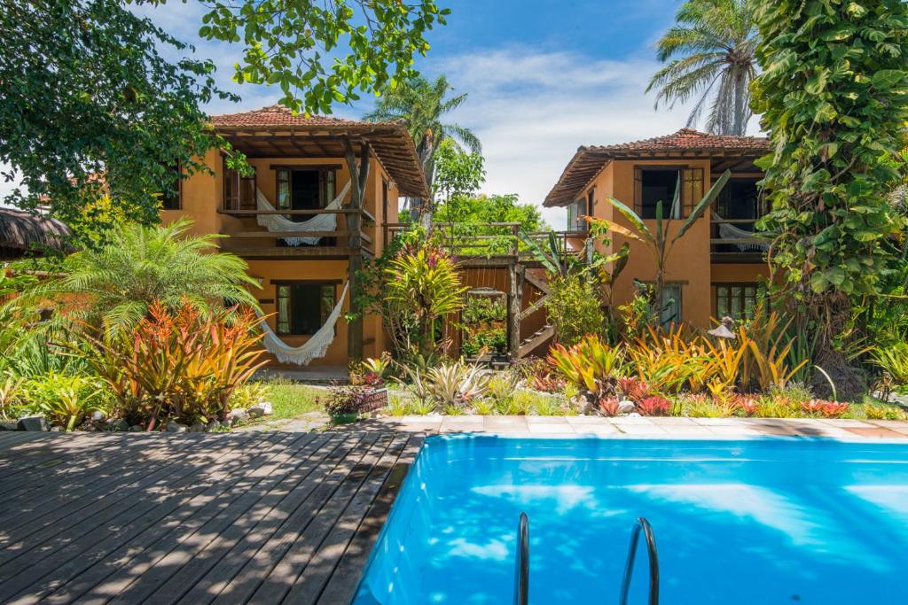 une villa avec une piscine en face d'une maison dans l'établissement Pousada Erva Doce, à Arraial d'Ajuda