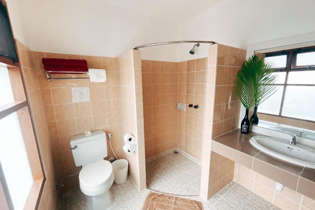 a bathroom with a shower and a toilet and a sink at Cruiser Island By Swiss-Belhotel in Ko Lone