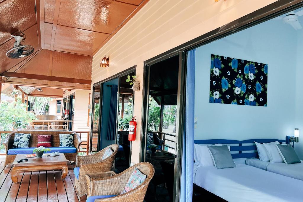 a porch with a couch and chairs and a table at Cruiser Island By Swiss-Belhotel in Ko Lone