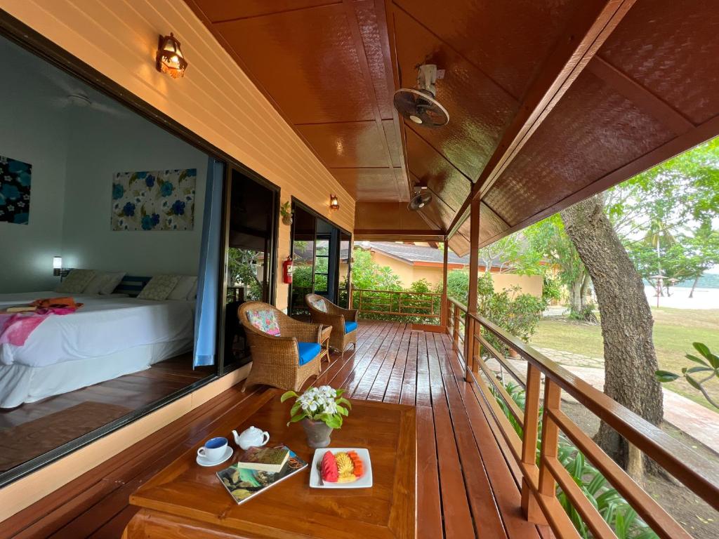 a room with a bed and a table on a deck at Cruiser Island By Swiss-Belhotel in Ko Lone