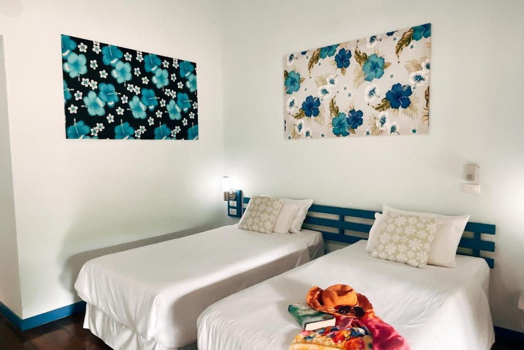 two beds in a room with flowers on the wall at Cruiser Island By Swiss-Belhotel in Ko Lone