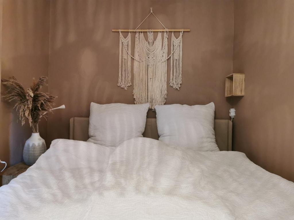 un letto con lenzuola e cuscini bianchi in una camera da letto di Radler Stall a Postbauer-Heng