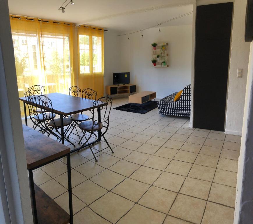 une chambre avec une table et des chaises ainsi qu'un salon dans l'établissement Lo pequelet, à Avignon