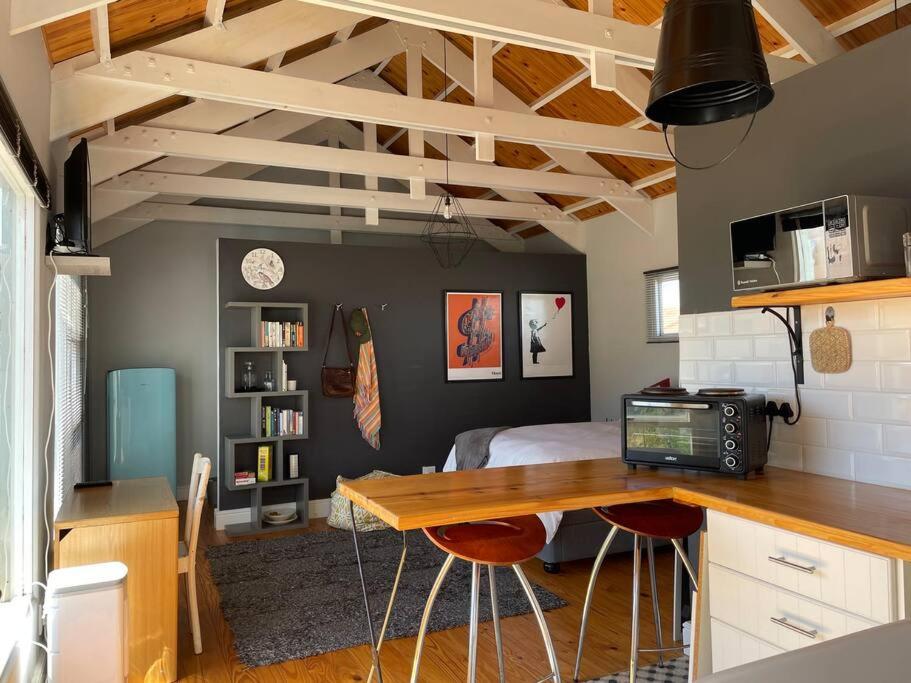 Habitación con cama y escritorio con ordenador. en Mountain View flat en Ciudad del Cabo