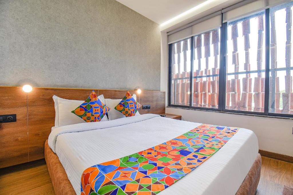 een slaapkamer met een groot bed en een groot raam bij FabHotel Brown Inn in Pune