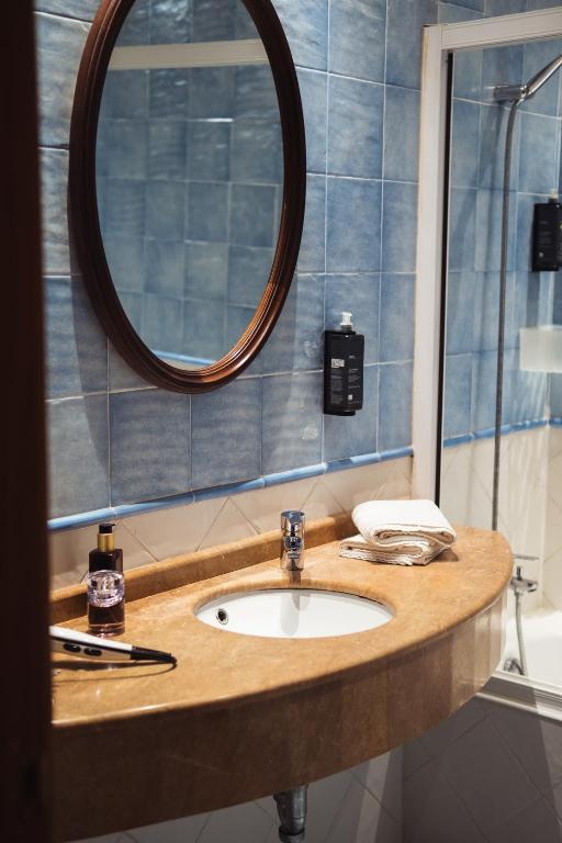 a bathroom with a sink and a mirror at San Sebastián DOT Rooms in San Sebastián