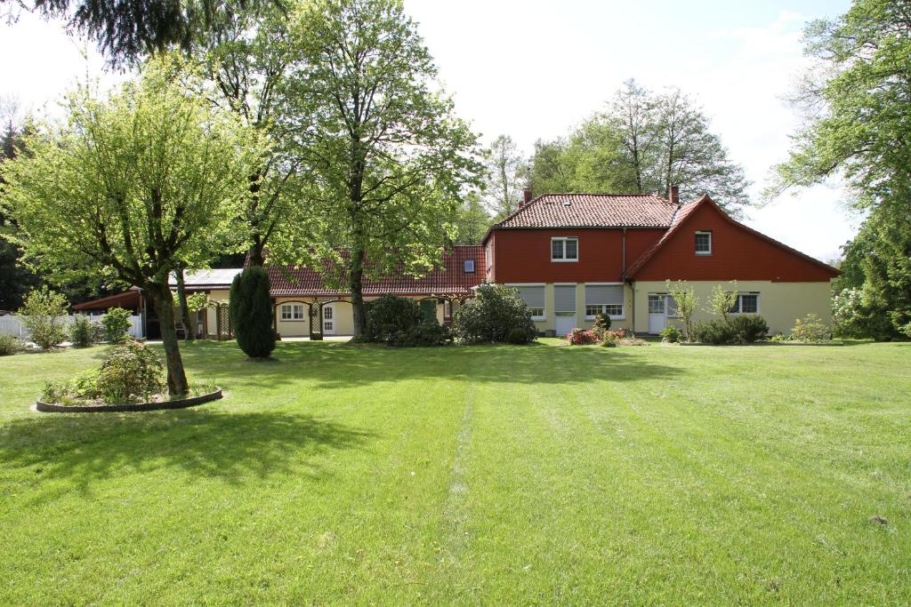 ゾルタウにあるGästehaus Heidehofの木の植わる緑の庭のある家