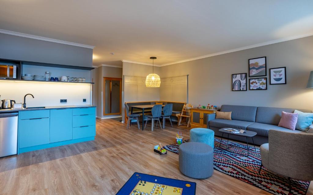 a kitchen and living room with a couch and a table at Elldus Resort in Kurort Oberwiesenthal