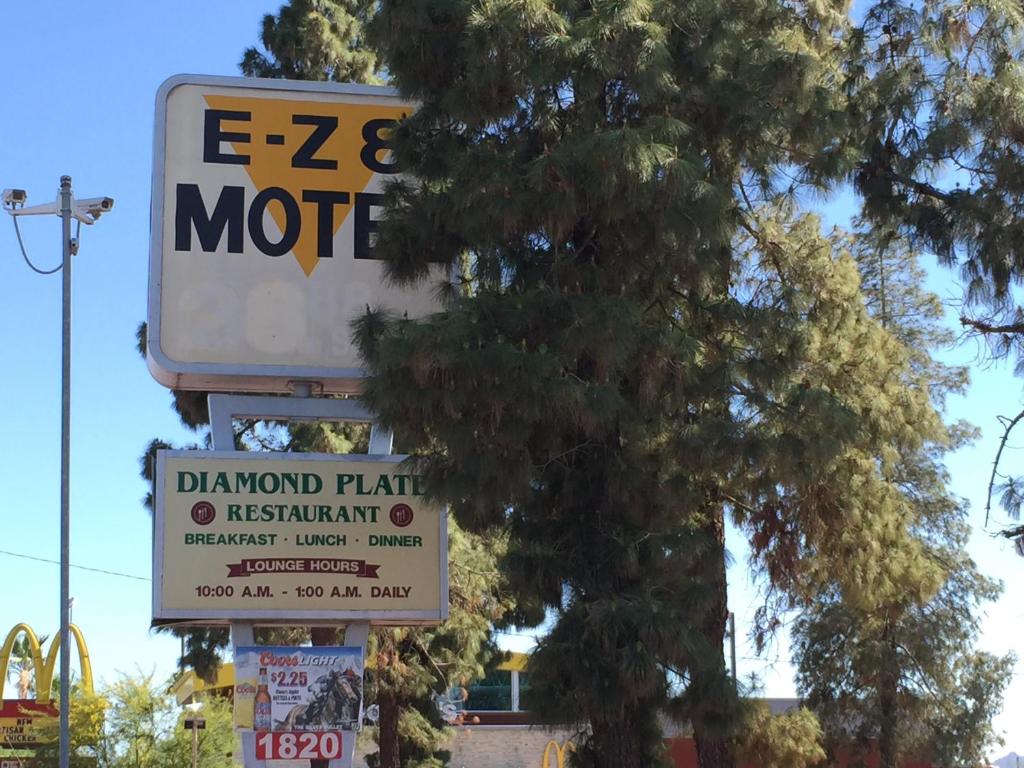 a sign for a restaurant next to a tree at EZ 8 Motel Airporter in Phoenix