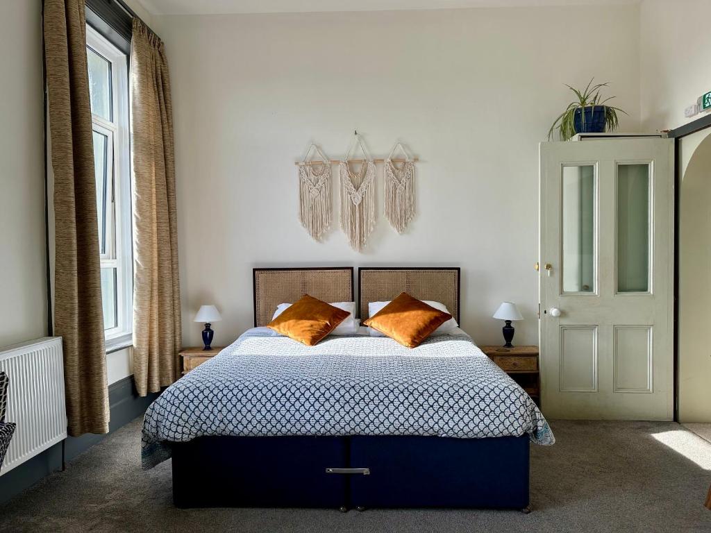 CloudZen في Kent: غرفة نوم مع سرير مع وسائد برتقالية
