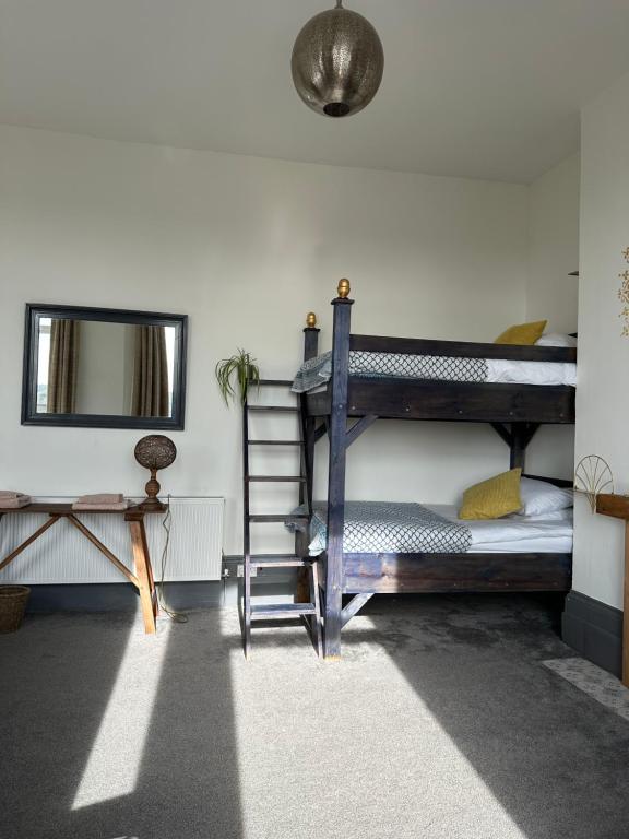 a bedroom with two bunk beds and a mirror at CloudZen in Kent