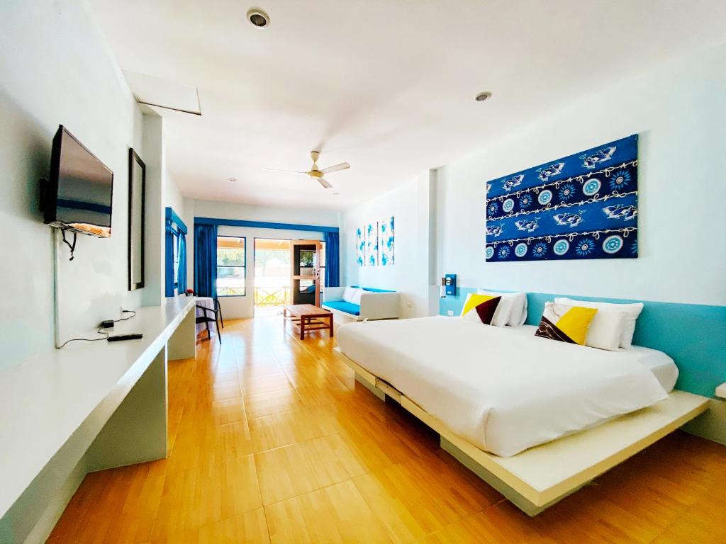 a bedroom with a large bed and a television at Cruiser Island By Swiss-Belhotel in Ko Lone