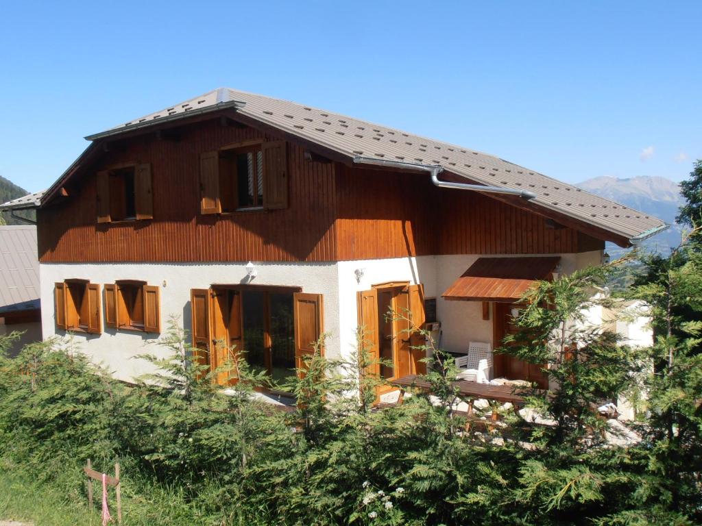 dom z drewnianym dachem na wzgórzu w obiekcie Chalet Bellevue w mieście Les Orres