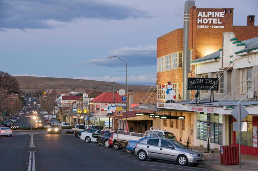 a city street with cars parked on the street at The Alpine Hotel in Cooma