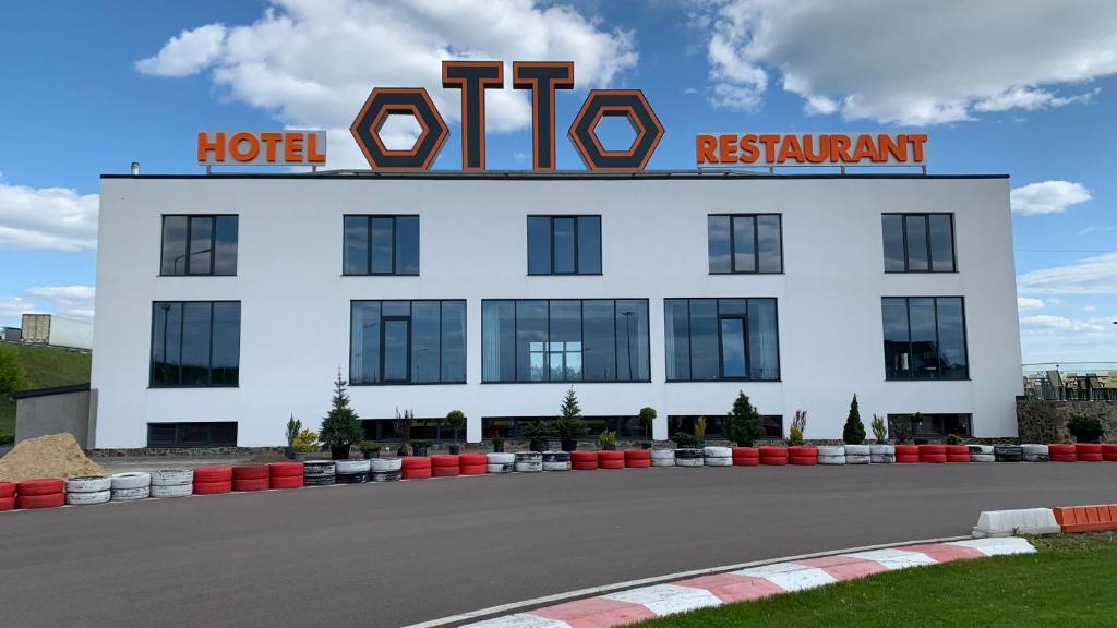 Un hôtel blanc avec un panneau rouge en haut dans l'établissement Otto Hotel-Restaurant, à Veresneve