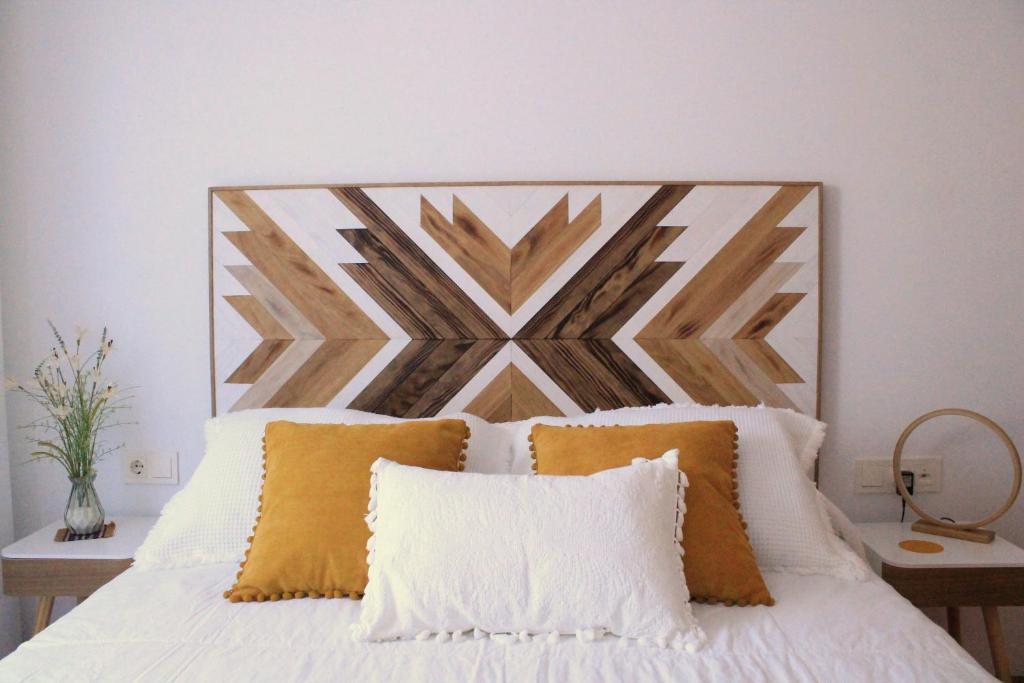 a bedroom with a bed with a large wooden headboard at La Caseta de Beli in La Galera