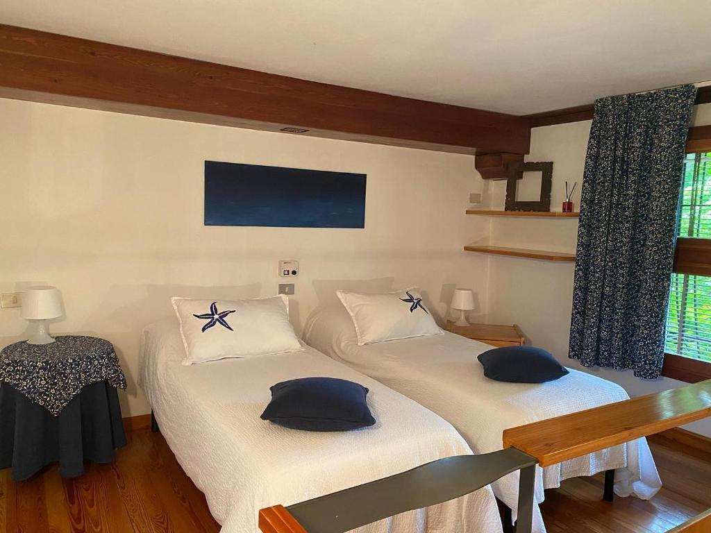 布雷西亞的住宿－La Valle B&B，一间卧室配有两张带蓝色枕头的床。