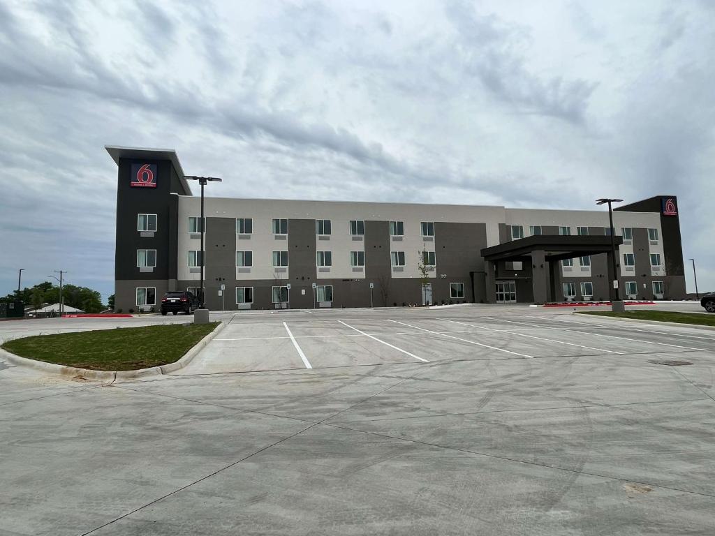 a large building with a parking lot in front of it at Studio 6 Fort Worth TX Lake Worth in Fort Worth