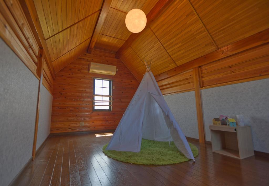 a room with a tent in the middle of a room at ocean resort mint オーシャンビューを満喫!かわいい三角屋根の三階建て貸切別荘 in Shioura