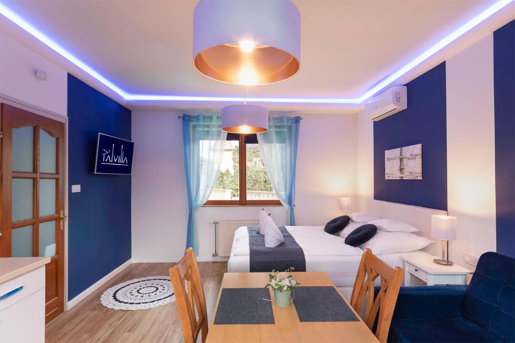 a living room with a bed and a dining room at Pál Villa - Premium Apartments - Kecskemét in Kecskemét