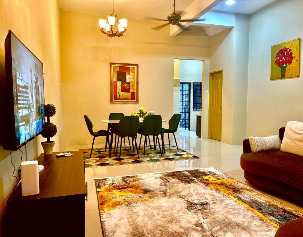 a living room with a table and chairs and a tv at Homestay D Razak Wakaf Tapai in Marang