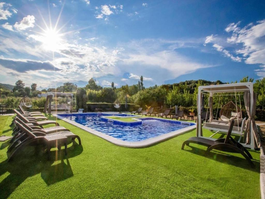 a backyard with a pool and lawn with lounge chairs at Apartments Villa Subic in Rab