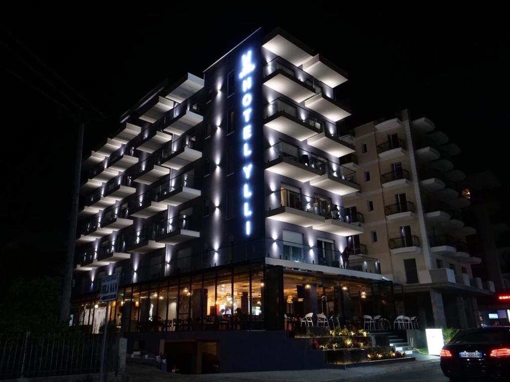 um edifício com luzes azuis à noite em HOTEL BAR RESTORANT YLLI em Shëngjin