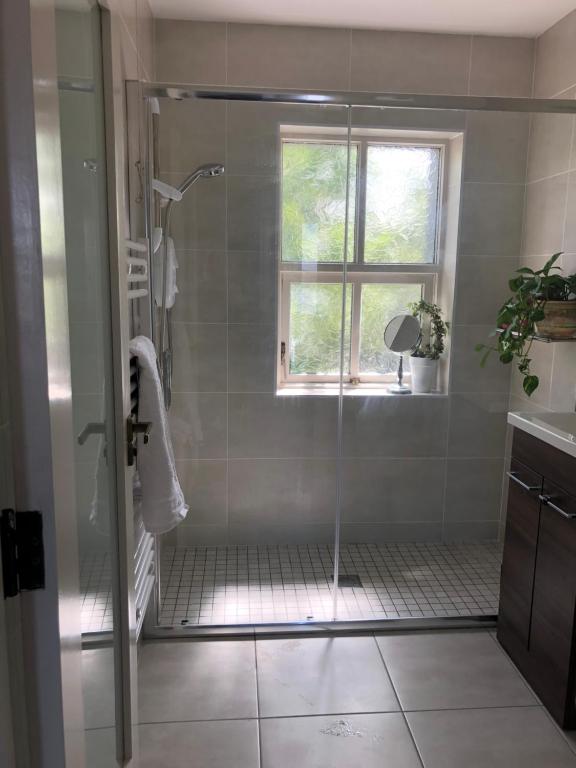 a bathroom with a shower with a glass door at 4 Harbour Town House in Westport