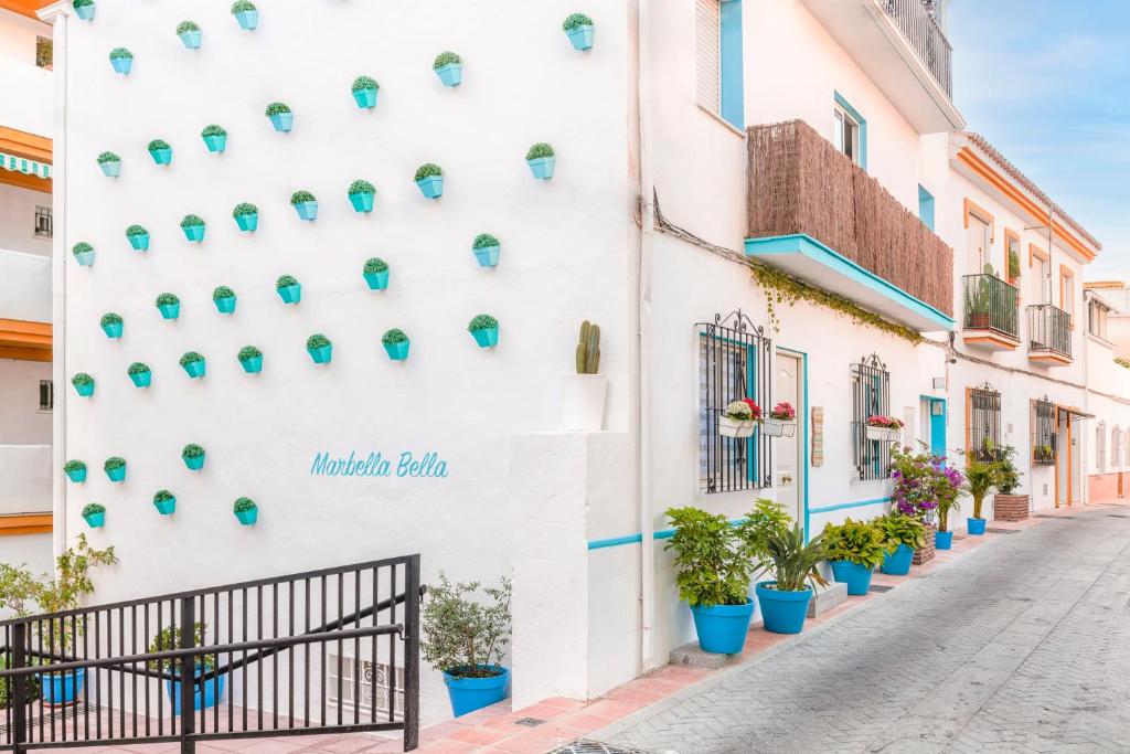 a white building with potted plants on it at Bella Marbella in Marbella