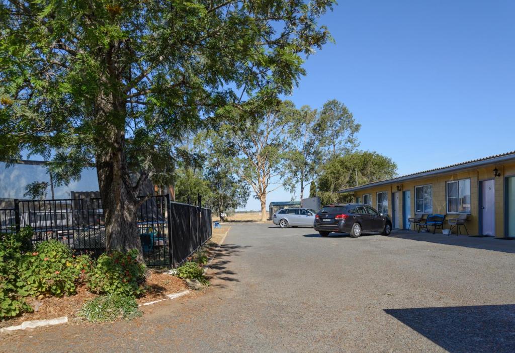 a car parked in a parking lot next to a building at Artesian Motor Inn in Coonamble